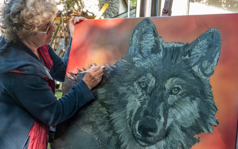 Corinne Dunand en pleine peinture d'un portrait de loup dans son atelier à Fabras en Ardèche