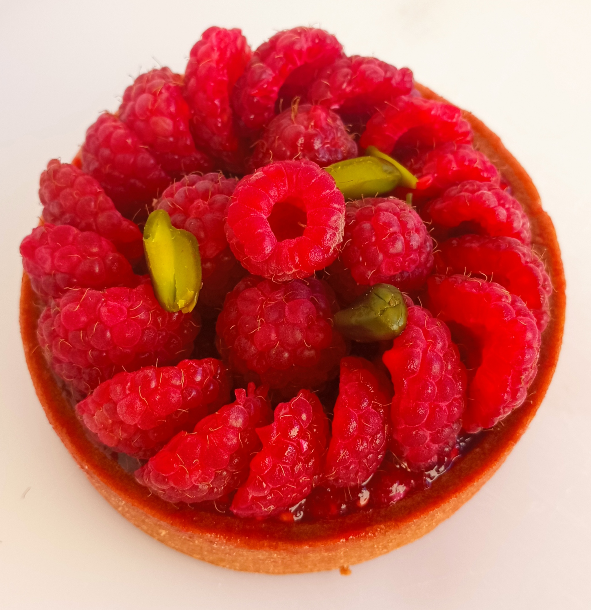 Tarte framboises pistaches réalisée par Tartelette & Co
