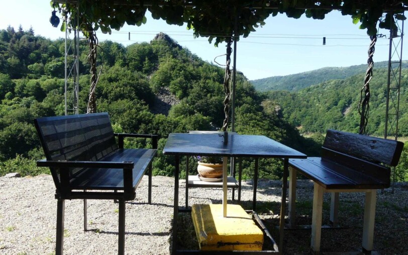 repas à l'extérieur sous pergolas, vue sur la nature.