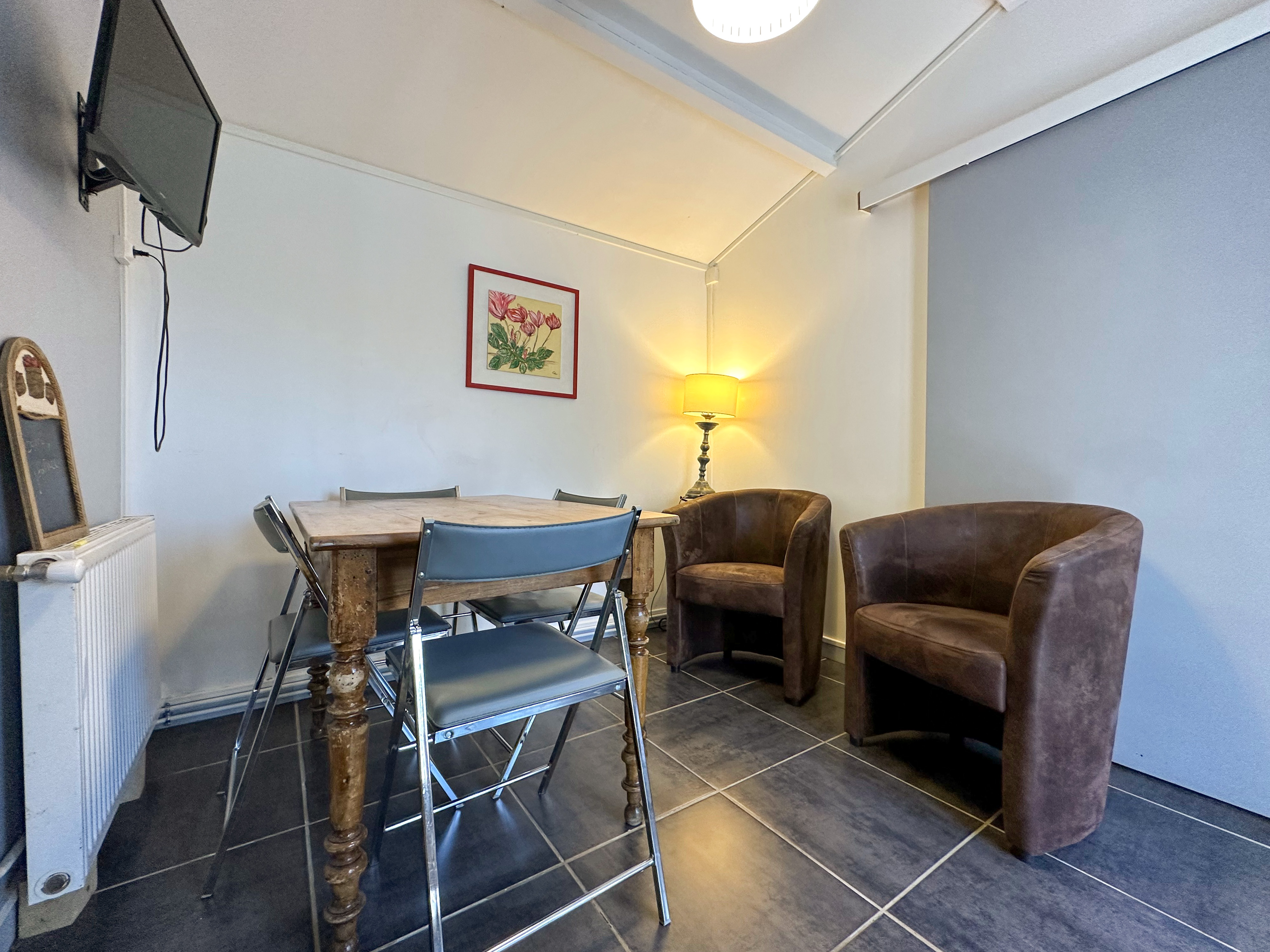 Salon avec deux fauteuils et tv